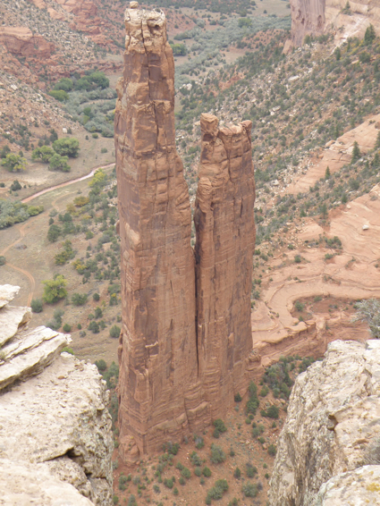 Two narrow rocks tower over a desert landscape