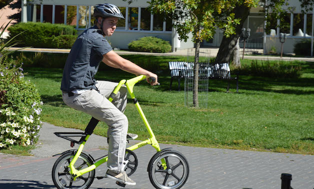 Spencer Shellborn riding a Strida Bike in a park.