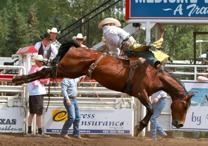 A cowboy rides a bucking horse