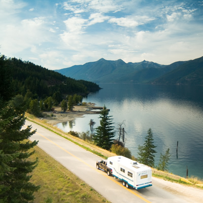 Picture of RV travelling along lakeshore road. 