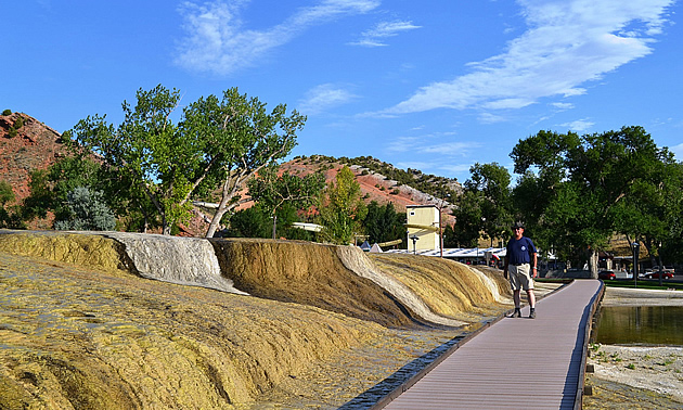 man standing next to a hot spring