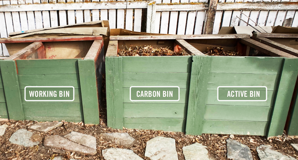 Three wooden bins filled with compost.
