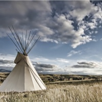 Photo of a teepee on the prairie. 