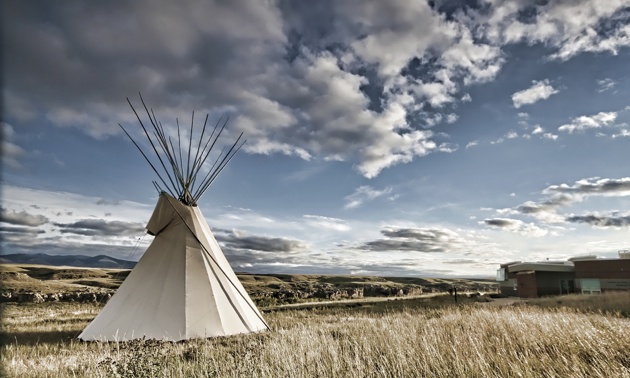 Photo of a teepee on the prairie. 