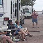 people sitting on lawn chairs in front of their RVs