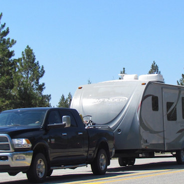 A truck and RV travelling down the highway.