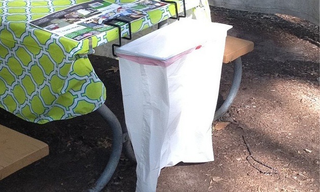 A Trash-Ease bag attached to a picnic table.