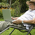 Man sitting in a lawn chair with a computer on his lap