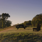 A man stands beside his RV and looks at the view of a lake.