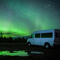 Ronn Murray's 8 passenger van with the aurora lights showing behind it. 