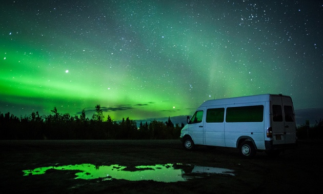 Ronn Murray's 8 passenger van with the aurora lights showing behind it. 