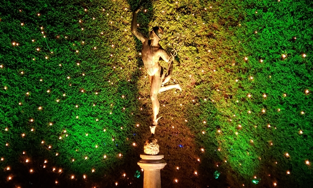 A sculpture in the Italian Garden at Butchart Gardens, with vibrant lighting behind the display.