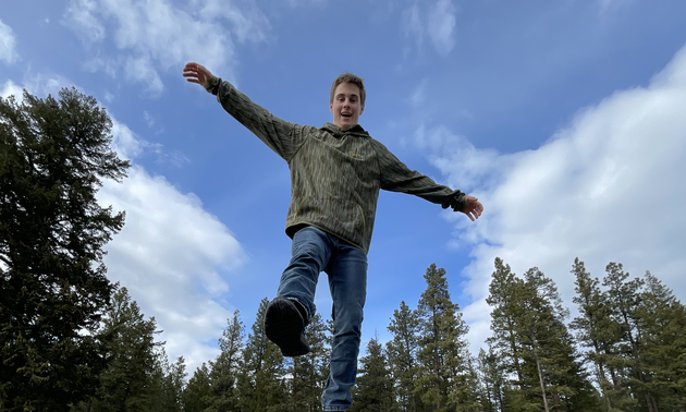 young man wearing an olive green Voormi hoodie