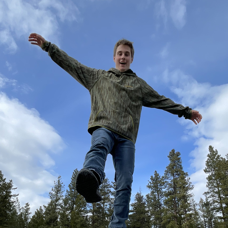 young man wearing an olive green Voormi hoodie