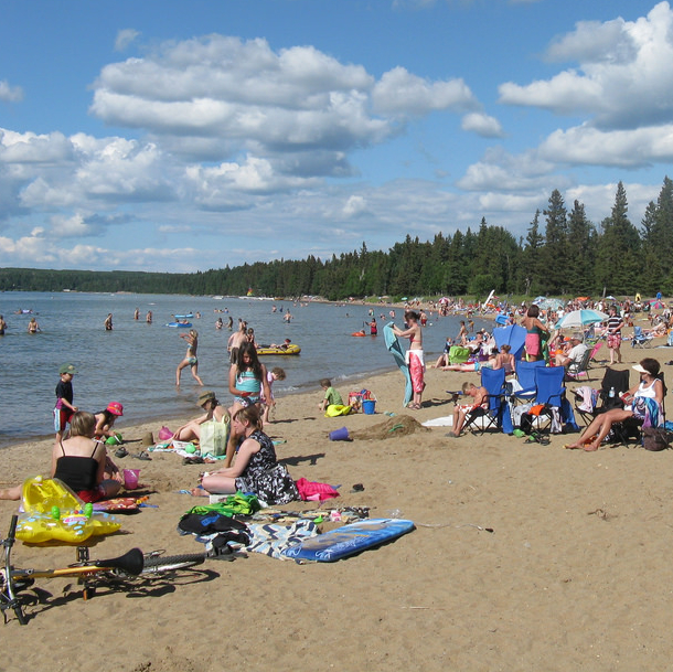 people gathered on a beach in Waskesiu Saskatchewan