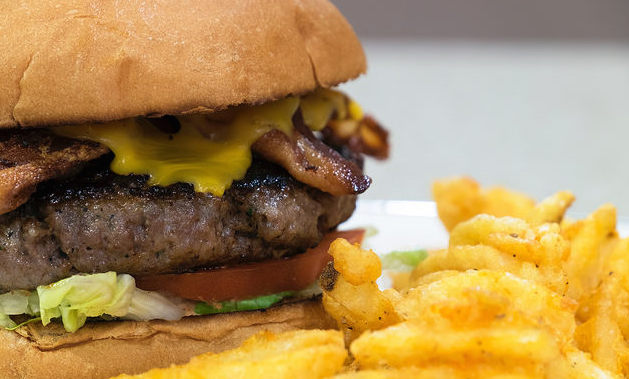 A loaded burger served with fries at John's Plate.