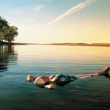 A woman floating in the minerals waters of Manitou Lake at sunset.