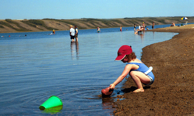 child with a bucket on the beach