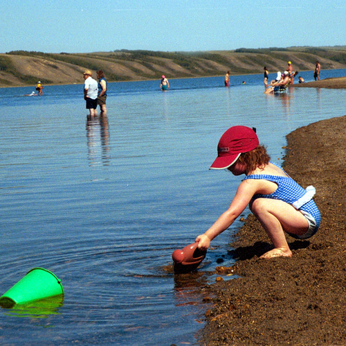 child with a bucket on the beach