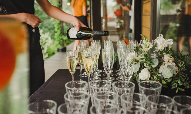 person pouring wine into glasses