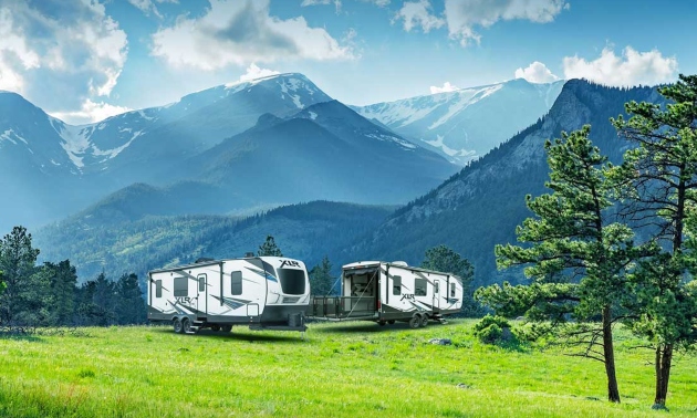 two RVs with mountains in the background