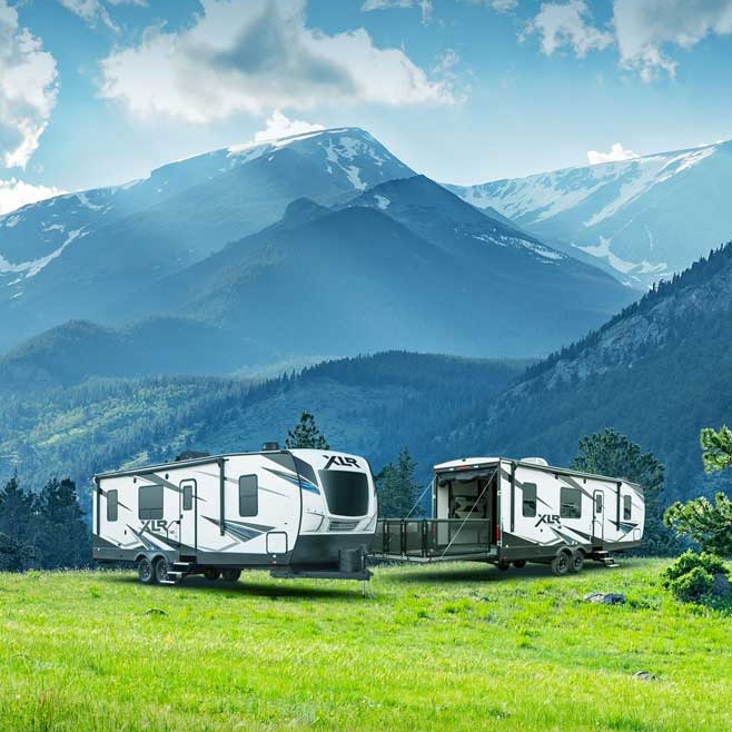 two RVs with mountains in the background